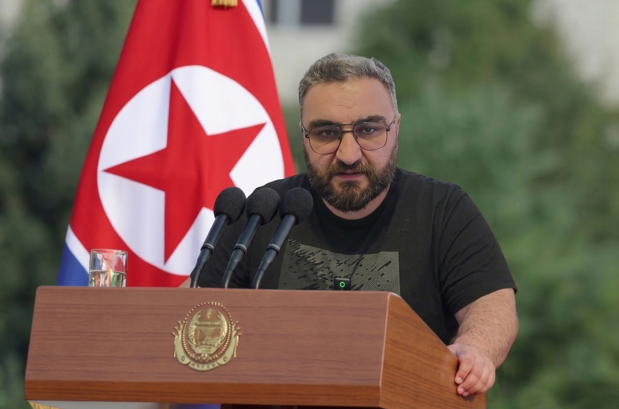 Kürsü ve bayrak önünde konuşma yapan kişi